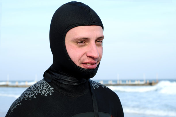 在水的背景冲浪板上穿着潜水服的冲浪者。冲浪,爱好图片下载