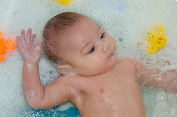 可爱的4个月大的男婴正在用泡沫洗澡图片下载