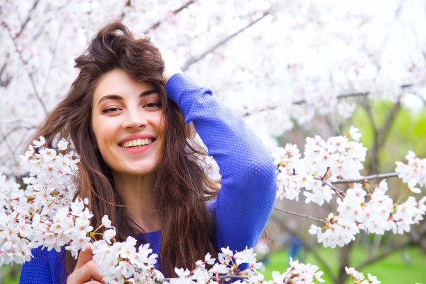快乐的女孩在盛开的樱桃树公园。图片下载