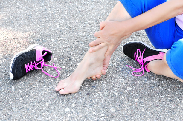 肌肉受伤。跑步受伤腿部事故——女子跑步运动员因抱伤腿部疼痛。女运动员在野外跑步训练中肌肉受伤，扭伤了腿。图片下载