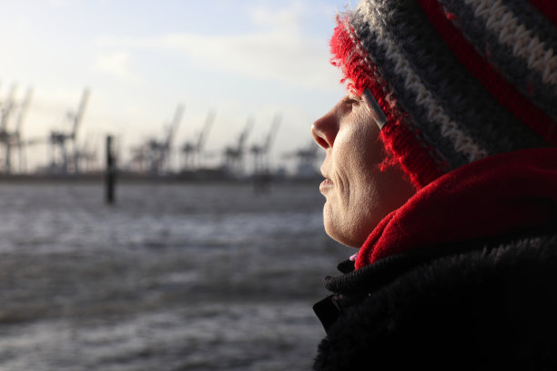 在德国汉堡的易北河上享受冬日阳光的女人图片下载