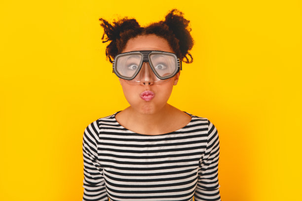 年轻的非洲妇女孤立在黄色墙壁工作室青少年风格戴潜水眼镜图片下载