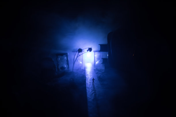 时间的概念。一个男人的剪影站在沙漏中间，在黑暗的背景上有烟雾和灯光。超现实主义的装修图片图片下载