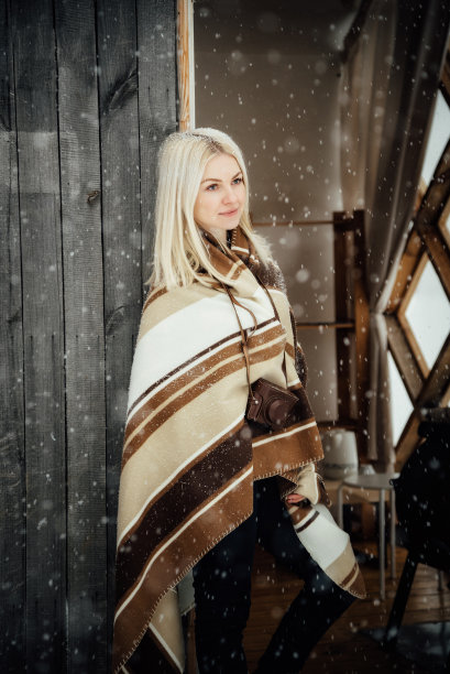 一个漂亮的金发女孩带着一个老式相机，在木墙背景上微笑图片下载