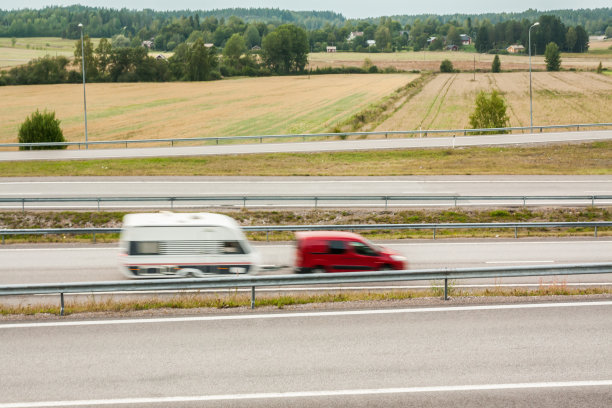 模糊的汽车在运动。芬兰秋天的柏油路和汽车。图片下载