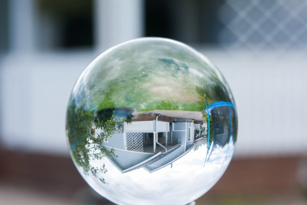 乡村木屋在玻璃球的映照下。图片下载