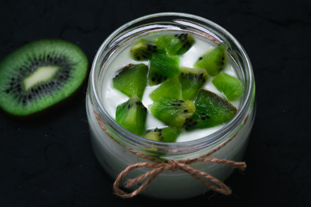 酸奶与猕猴桃片在黑色的背景图片下载