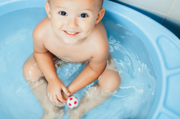 快乐的小男孩在浴缸里游泳图片下载