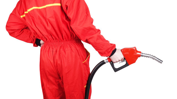 人加油站工作人员正拿着红色汽油手枪泵燃油喷嘴从后面看后视图图片下载