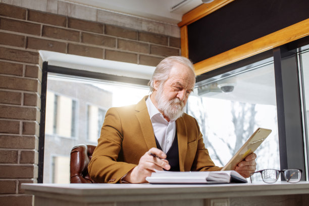 近距离看照片的老人在平板电脑上工作图片下载