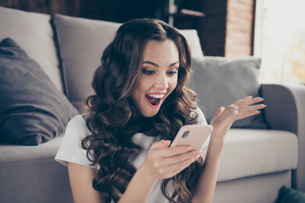 近距离的照片美丽的黑发的她她的夫人笑的笑声电话意外的收入自由职业者的工作穿着运动的家庭浅色的t恤裤子衣服装坐地板舒适的沙发图片下载