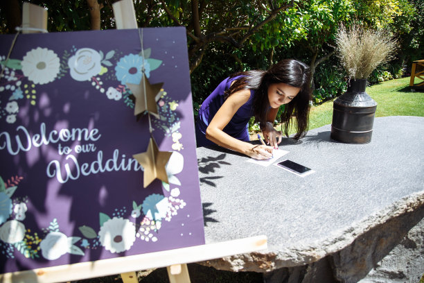 一名年轻女子在婚礼当天在户外为新婚夫妇写祝福图片下载