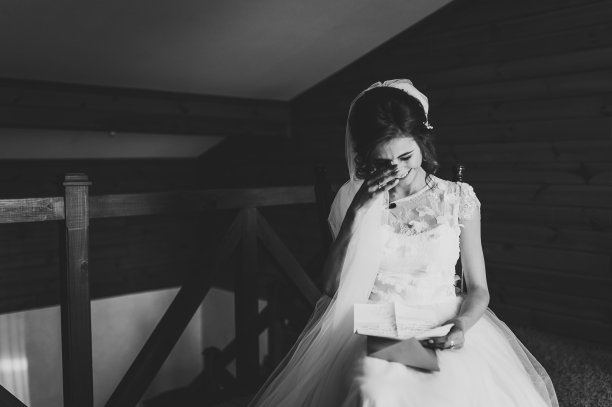 美丽的新娘为爱读着新郎的来信。新娘的眼泪，幸福的喜悦。新娘坐在窗边，给新郎读信。结婚誓言。新娘的早晨。黑白照片。图片下载