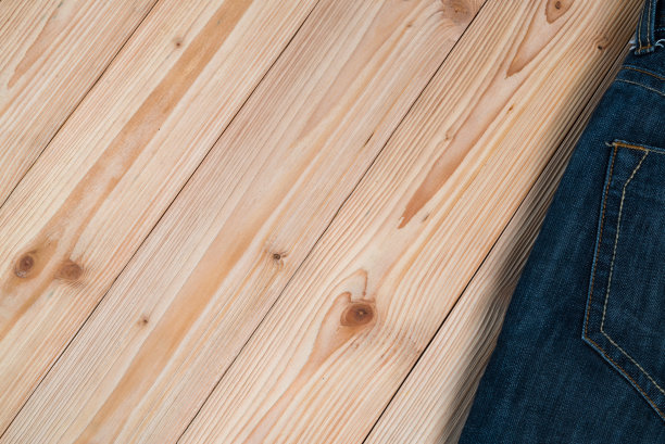 磨损牛仔裤或蓝色牛仔裤牛仔收集粗糙的木制桌子背景与拷贝空间，旧的时尚概念。图片下载