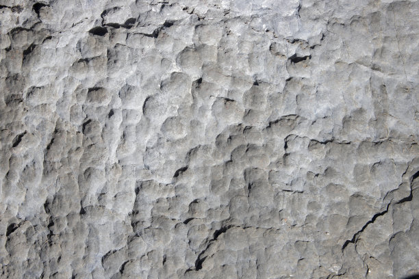 白色岩石质地粗糙。石头表面的照片。有切割痕迹的石面。老石墙特写。图片下载