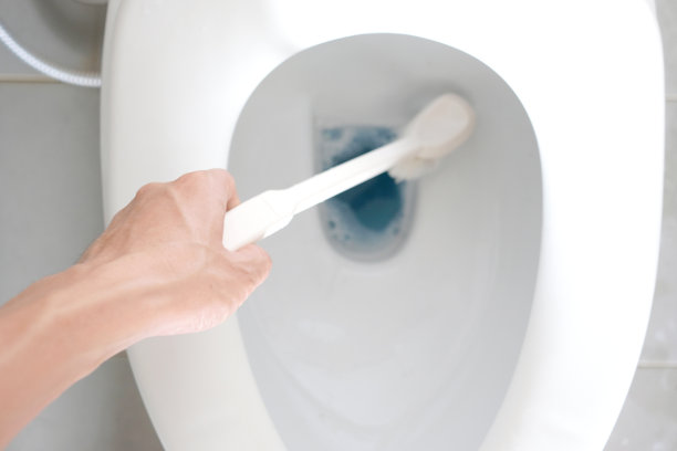 男人的手用干净的刷子刷他。家里浴室里的脏马桶图片下载