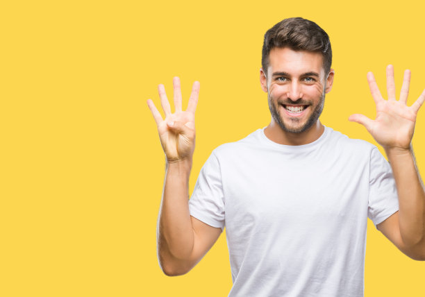 年轻英俊的男子在孤立的背景显示和指向第九，同时微笑着自信和快乐的手指。图片下载
