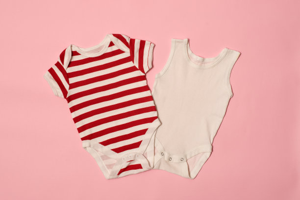 婴儿时装概念上的粉色背景。条纹和白色的紧身衣图片下载
