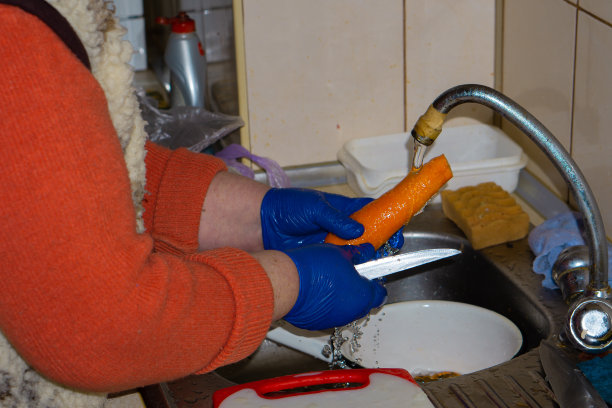 年长妇女在厨房手洗胡萝卜图片下载