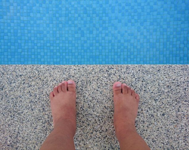 孩子的脚站在游泳池上图片下载