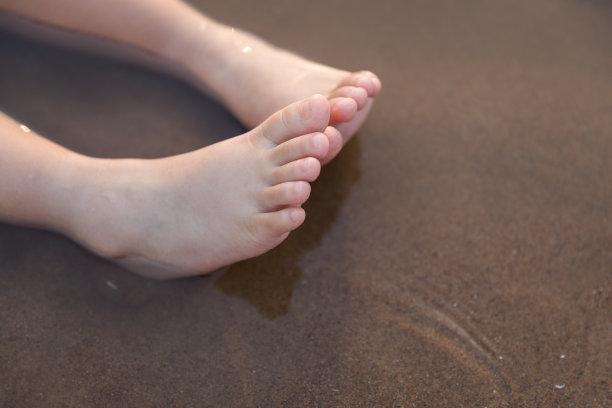 海滩上的婴儿脚特写图片下载