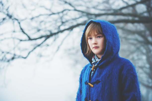 户外肖像小9-10岁的小女孩在一个非常雾天，穿着深蓝色外套和兜帽素材图片