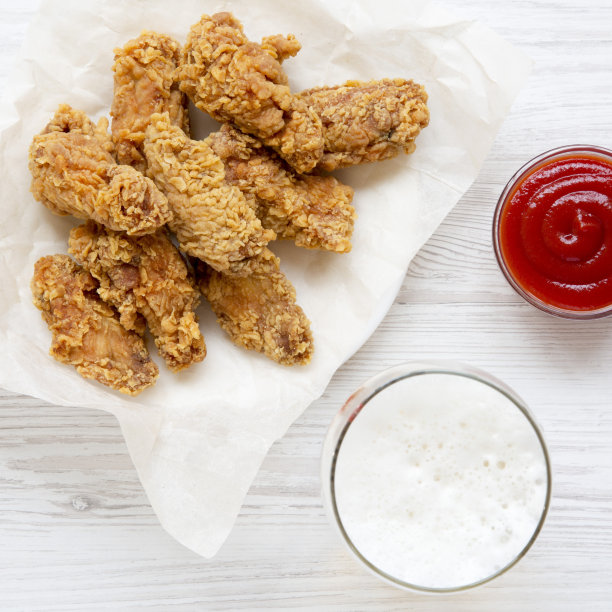 俯视图，红辣椒酱炸鸡翅，冰啤酒，俯视图。平坦的躺,开销。图片下载