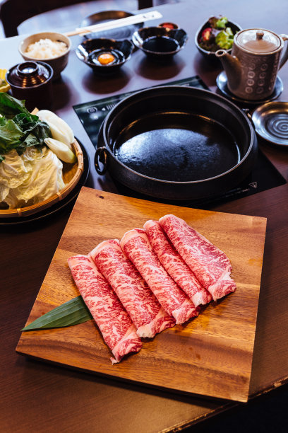 上等罕见的和牛A5片，高大理石纹理的方形木盘子，供素喜烧和日式火锅使用。图片下载