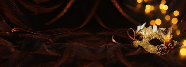 照片优雅和精致的金色威尼斯面具在黑暗的丝绸背景。图片下载