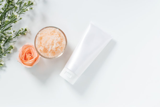 皮肤护理的概念。平铺的护肤品风格在白色挤压管包装与空白标签和盐温泉在玻璃碗与天然材料隔离在白色背景素材图片