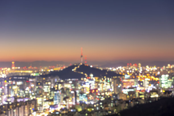 在首尔城和首尔大厦的背景上，城市模糊的灯光抽象出了散景。图片下载