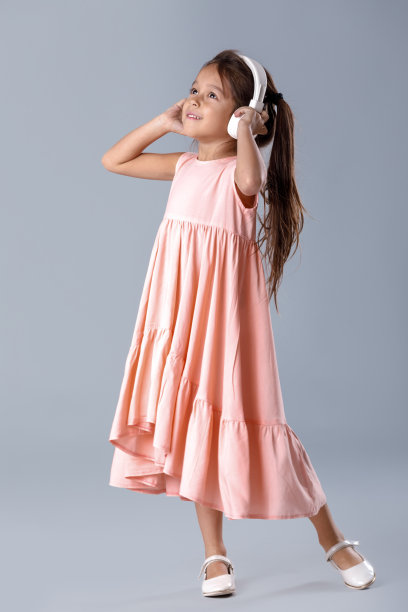 小女孩穿着衣服戴着耳机听音乐跳舞图片下载