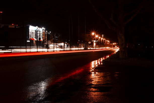 夜晚的城市街道。模糊的灯光。湿沥青。图片下载