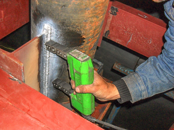 检验员正在用磁粉探伤法对管道焊缝进行检测。磁粉探伤(MPI)是一种检测表面的无损检测(NDT)方法。图片下载