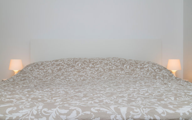 卧室的床前有床单和枕头，两侧有床头灯。舒适，选择床垫睡觉图片下载