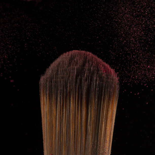 近距离粉飞溅和刷化妆艺术家或美容博客在黑色的背景图片下载