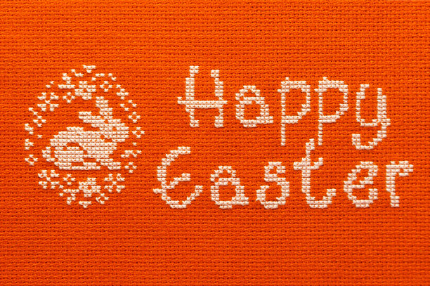 画布上绣有复活节快乐和兔子的题词。图片下载
