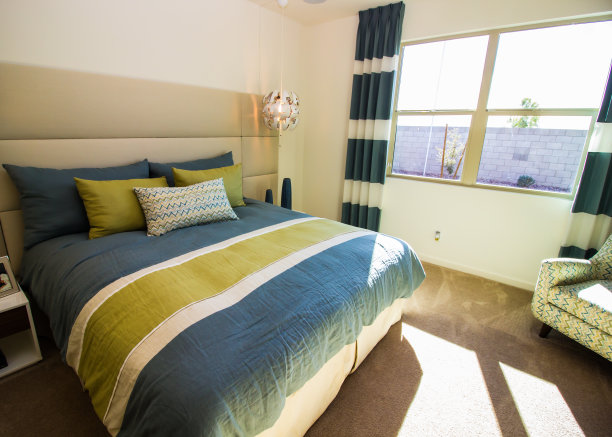 在晨曦中，铺着彩色床单的床图片下载