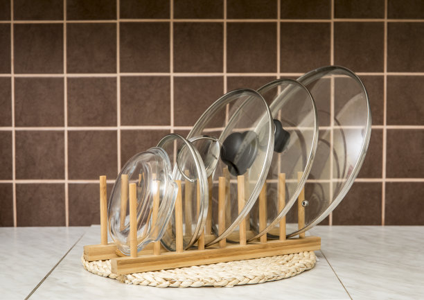 木制的自然颜色的架子，在厨房里用来放锅/锅盖，背景是棕色的瓷砖。厨房组织者室内元素工具概念。图片下载