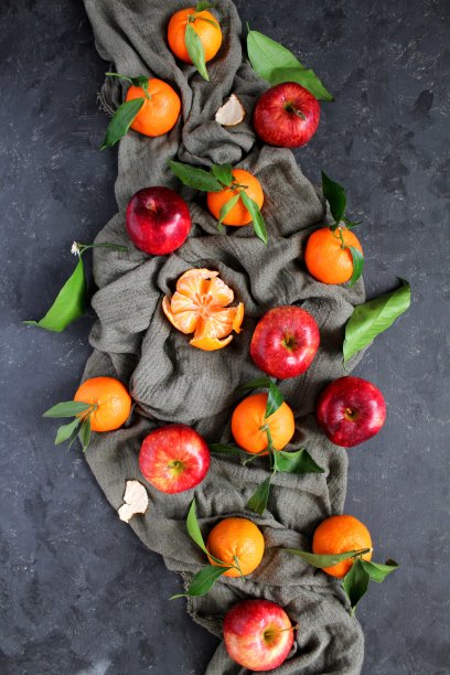 黑色背景上的红苹果和橘子。图片下载