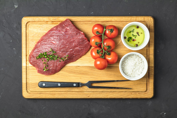 新鲜的生肉牛肉在木砧板上与配料烹饪图片下载