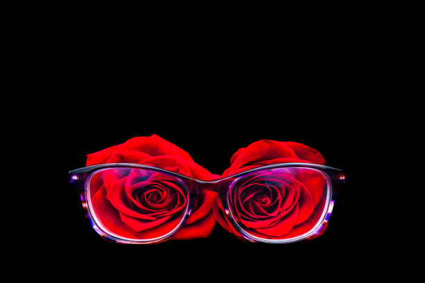 黑色背景上的两朵玫瑰和一副紫色眼镜图片下载