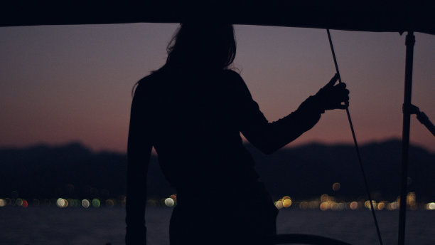 从船上看到的海上日落。女人的轮廓图片下载