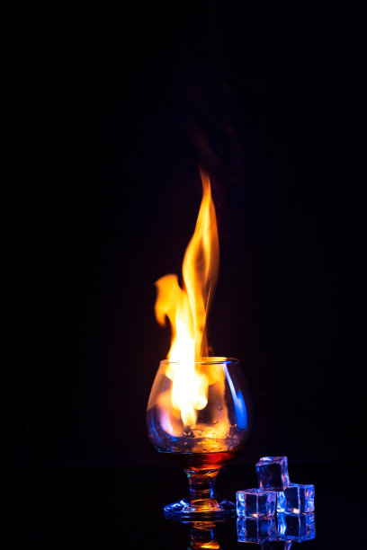 玻璃燃烧酒精和冰在黑暗的背景图片下载