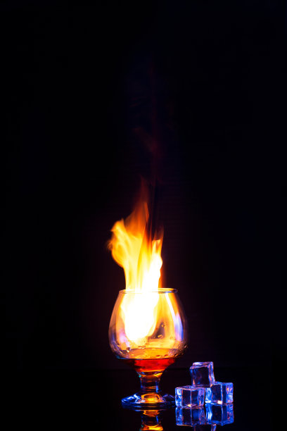 玻璃燃烧酒精和冰在黑暗的背景图片下载