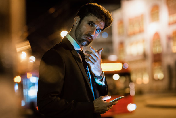 英俊的商人使用他的智能手机图片下载