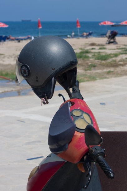 在海滩附近的摩托车上戴头盔图片下载