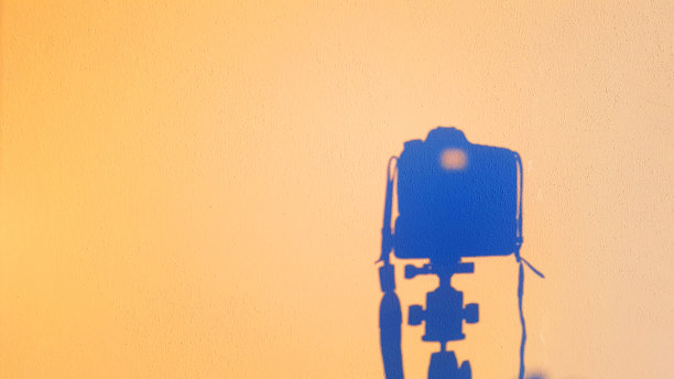 日落时墙上的相机反射剪影，技术摄影的概念图片下载