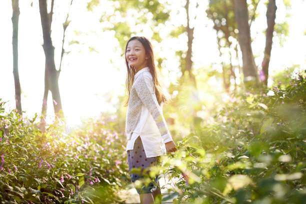 一个亚洲小女孩站在花地里图片下载