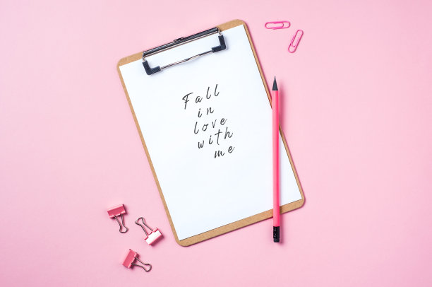 粉色背景上的剪贴板和铅笔。文本或设计的模板图片下载